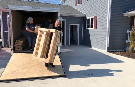 Levi King helps unload wooden materials used to assemble beds for The Farm Place.