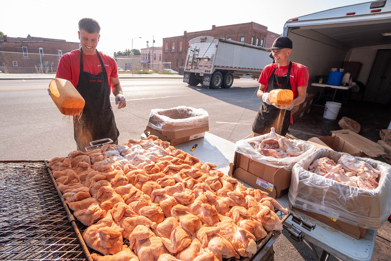 Workers from King's BBQ season chicken for The Farm Place's BBQ fundraiser